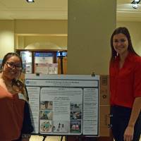 Annie Phommala and Grace Kenney with their poster